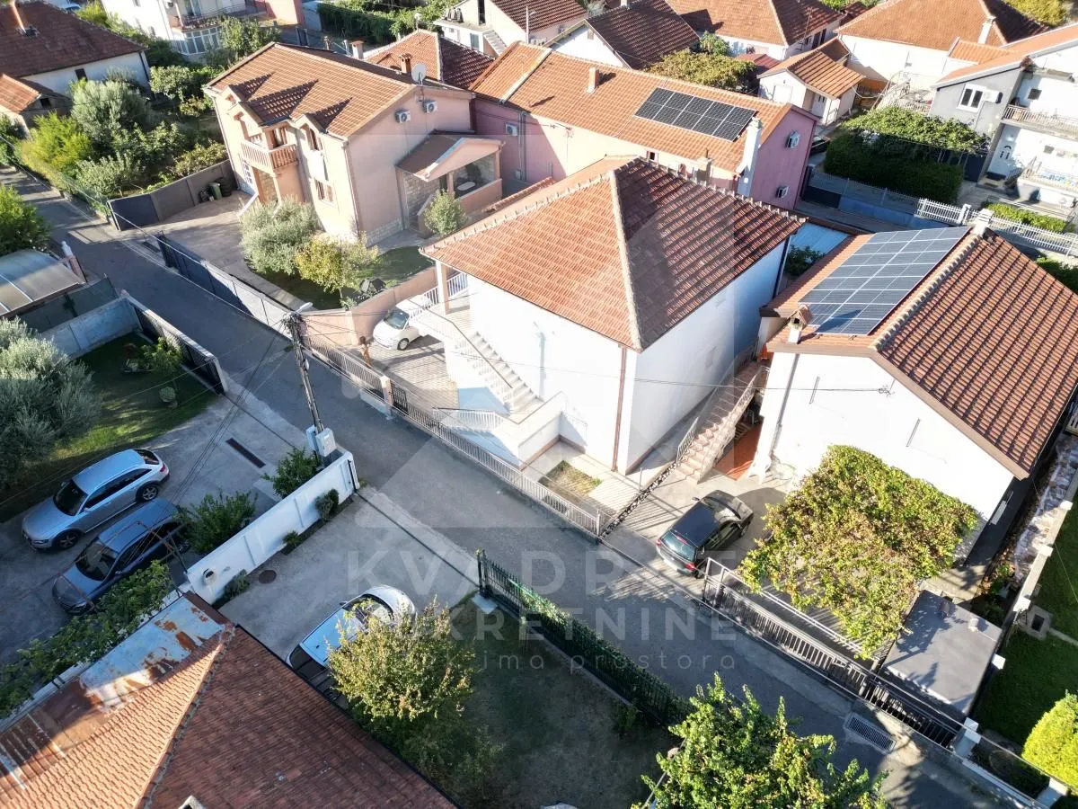 Pogled iz vazduha na kuću i okolno naselje sa dvoriijem.