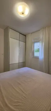 Furnished bedroom with a large double bed, wardrobe, and window. - image 3