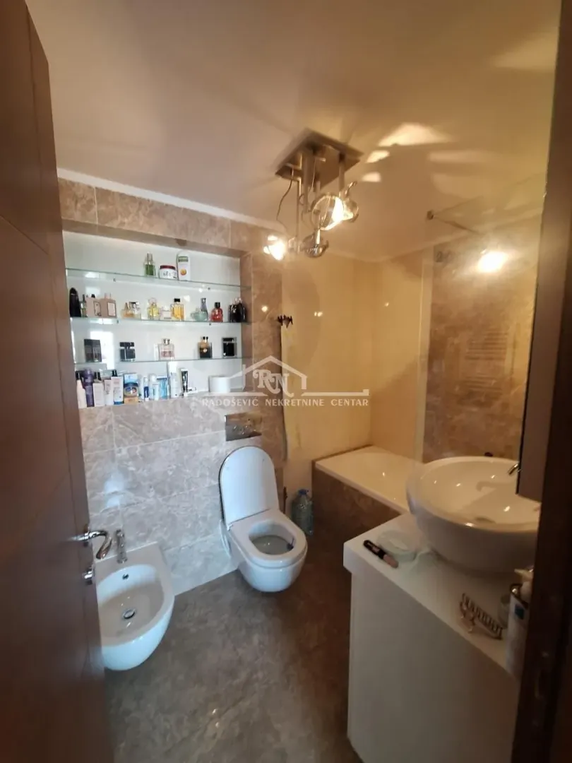 Potpuno opremljeno kupatilo sa kadom, umivaonikom i toaletnim elementima.