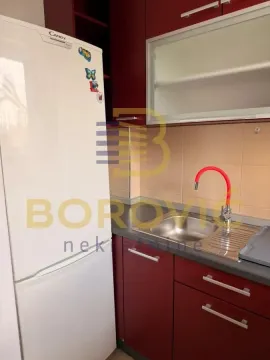 Deo kuhinje sa sudoperom, radnom površinom i frižiderom. - image 2