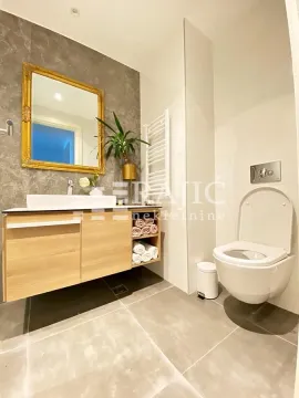 Modernly decorated bathroom with a washbasin and toilet. - image 12