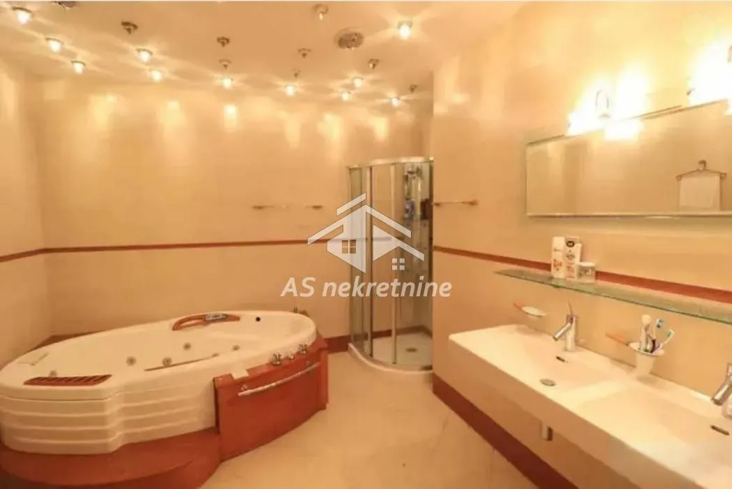 Spacious bathroom equipped with a corner bathtub, shower cabin, and double sink.