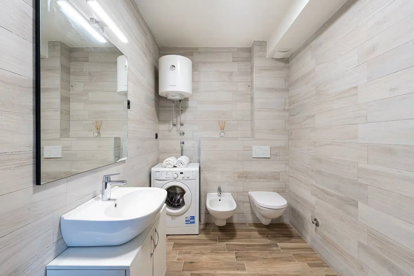 Moderno opremljeno kupatilo sa umivaonikom, WC šoljom, bideom i veš mašinom.