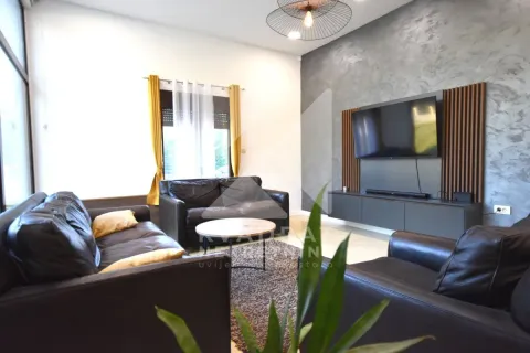 Living room with leather sofas, a coffee table, and a wall-mounted TV. - image 19