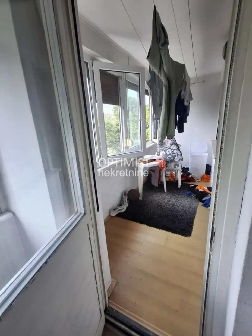 Zastakljeni balkon sa prostorom za sušenje veša i prozorom.