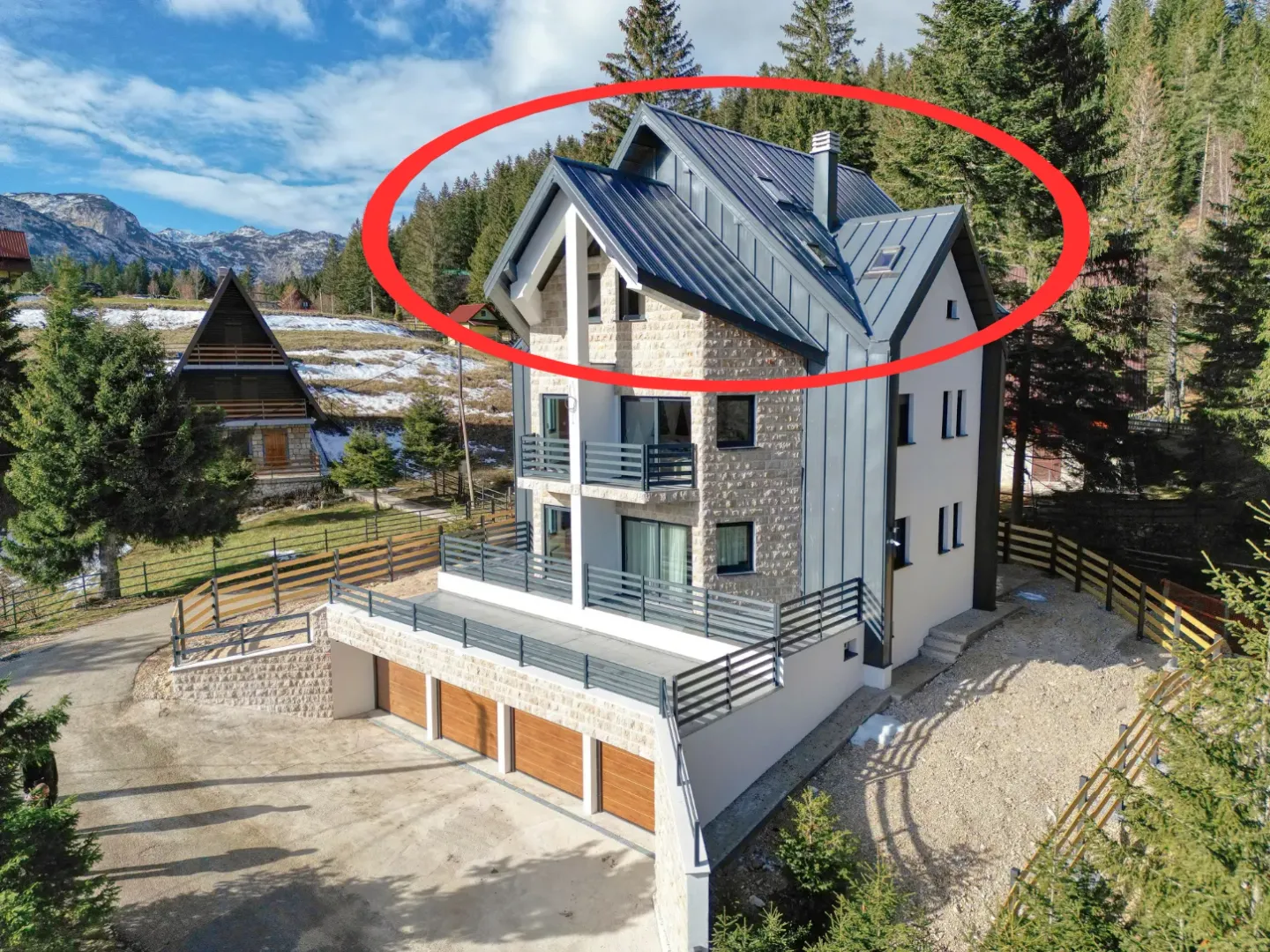 Spoljašnji izgled višespratne kuće sa kamenom fasadom i detaljima od lima u planinskom okruženju.