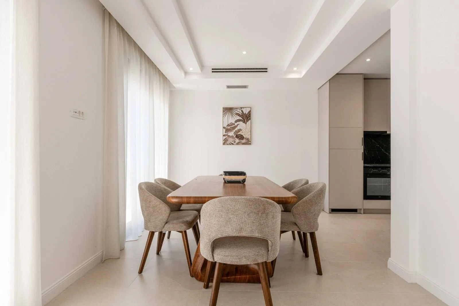 Modern dining area with a wooden table and chairs connected to the kitchen.