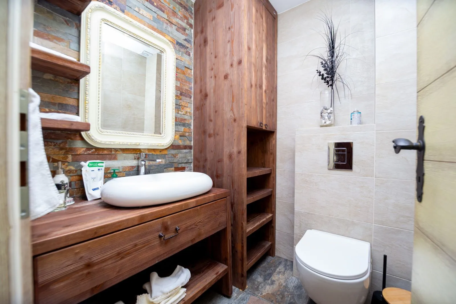 Modern bathroom with wooden elements and a stone wall.