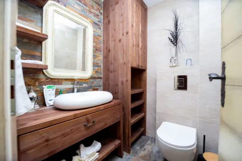 Modern bathroom with wooden elements and a stone wall. - image 20