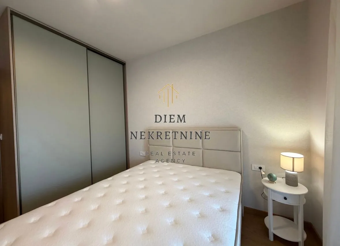Modern bedroom with a double bed, wardrobe, and a nightstand.