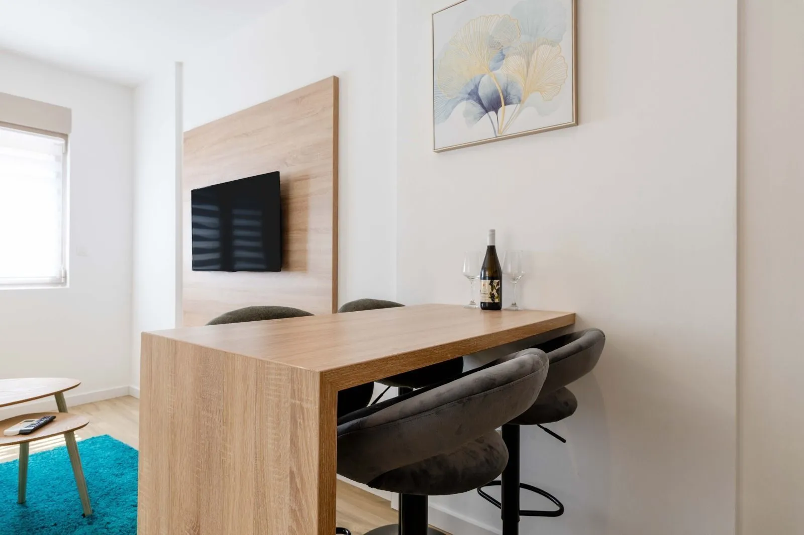 Modern seating corner with a dining table and a wall-mounted TV.