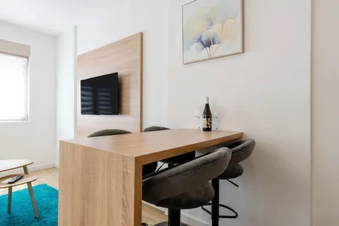 Modern seating corner with a dining table and a wall-mounted TV. - image 11