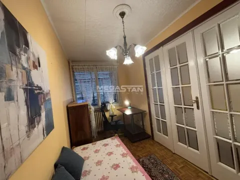 Furnished bedroom with a bed, a desk, and white double doors. - image 9