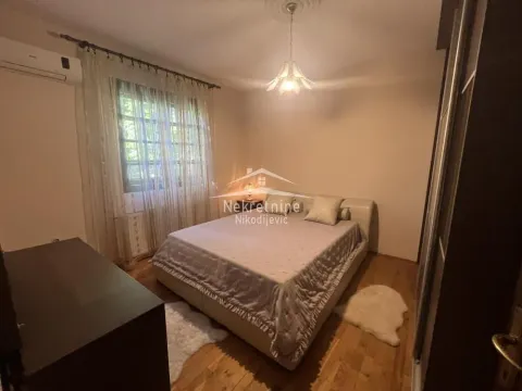 Furnished bedroom with a double bed, wardrobe, and window with curtains. - image 13