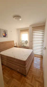 Bedroom with a double bed, wooden parquet flooring, and windows with blinds. - image 2