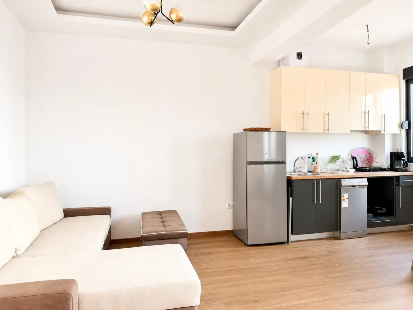 Living room with kitchen in bright tones.