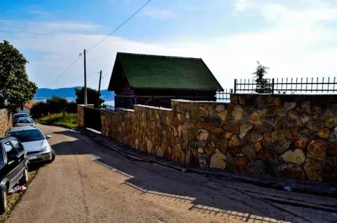 Pogled sa ulice na kuću sa dvorištem ograđenim kamenim zidom. - image 5