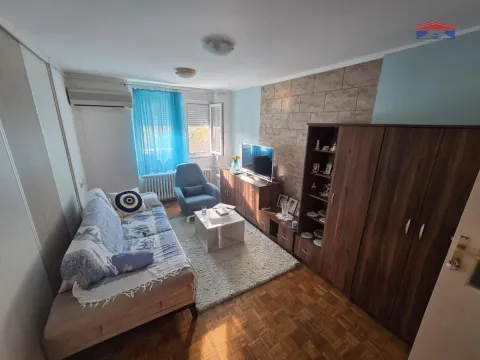 Dnevna soba sa garniturom, TV-om i drvenim nameštajem. - image 3