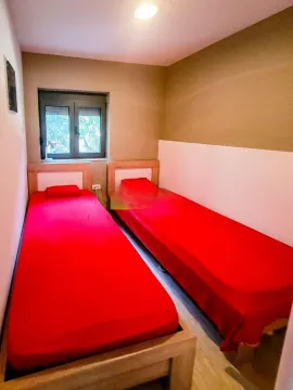 Manja spavaća soba sa dva singl kreveta i prozorom. - image 17