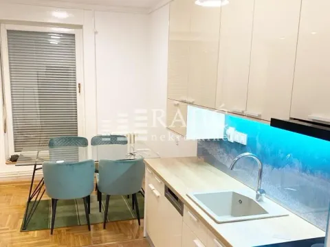 Modern kitchen with a dining area and built-in units. - image 2