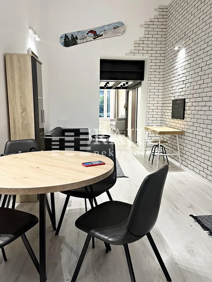 Dining area with a table and black chairs in a modern apartment.