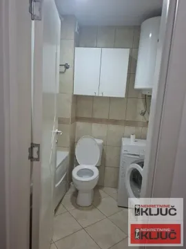 Pogled na kupatilo sa sanitarijama, ormarićem i mašinom za veš. - image 9
