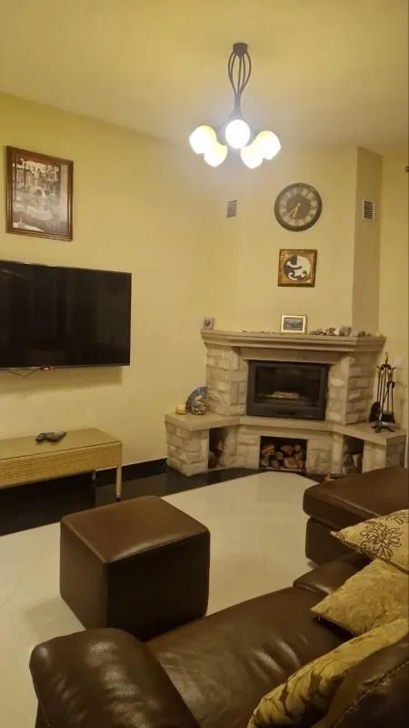 Living room with a sofa set, fireplace, and television.