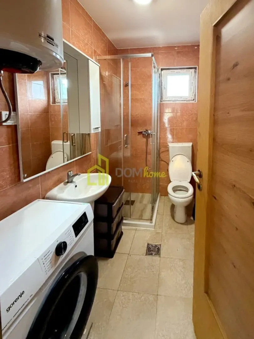 Bathroom equipped with a shower cabin, washbasin, toilet, and washing machine.