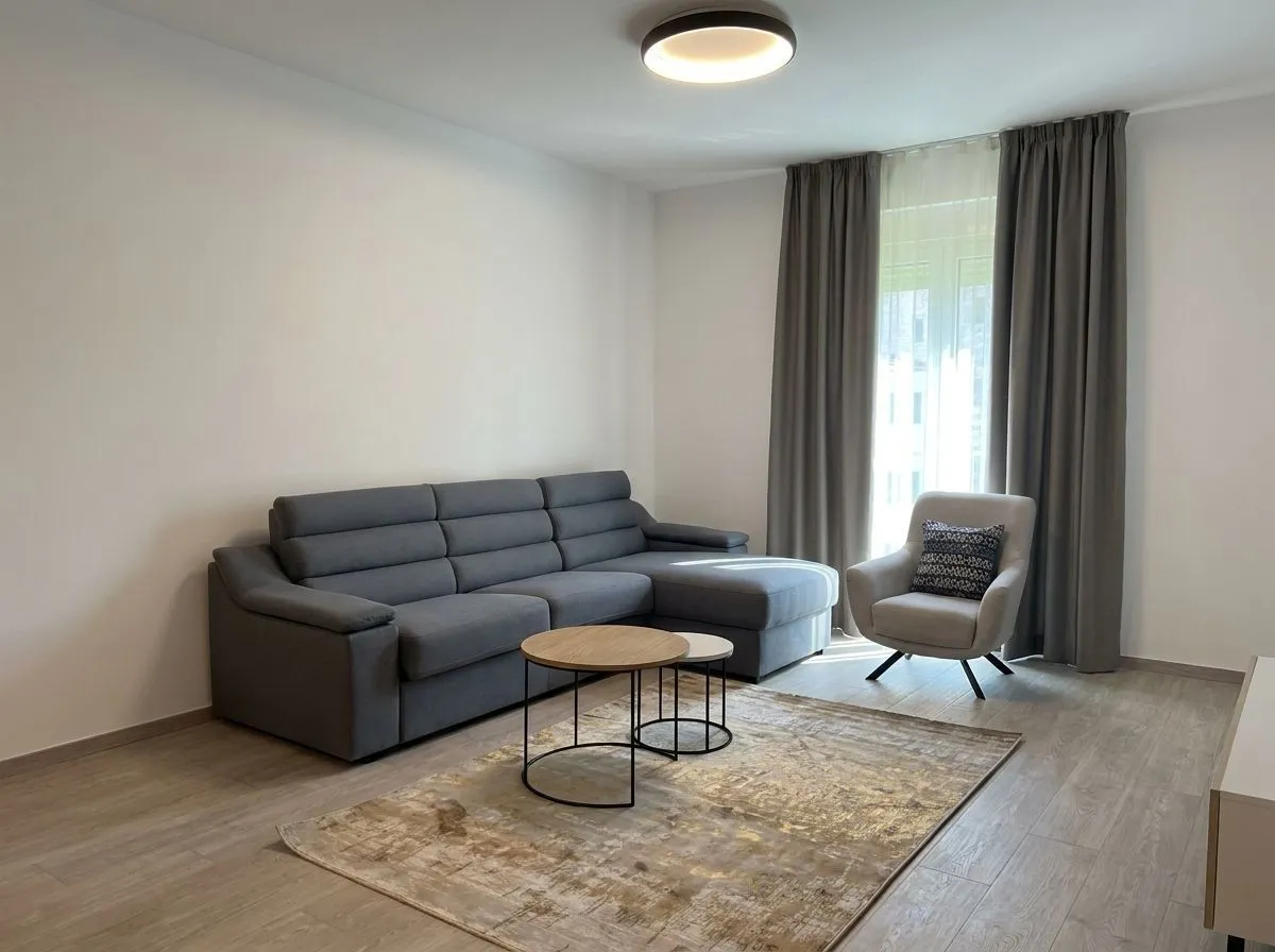 Living room with a grey sectional sofa, an armchair, and a coffee table.