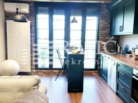 Modern kitchen with a breakfast bar and dark cabinetry. - image 10
