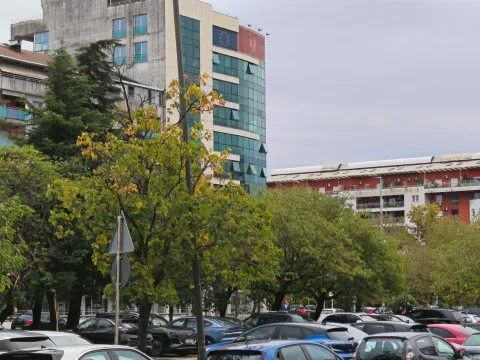 View of the building and surrounding area with parked cars in the foreground. - image 2