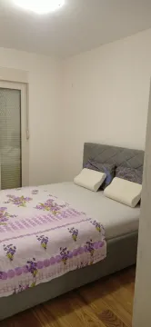 Tidy bedroom with a double bed and a window. - image 4