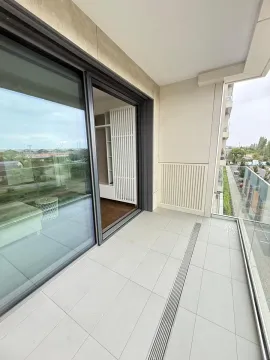 Spacious covered balcony with glass railing and surrounding view. - image 17
