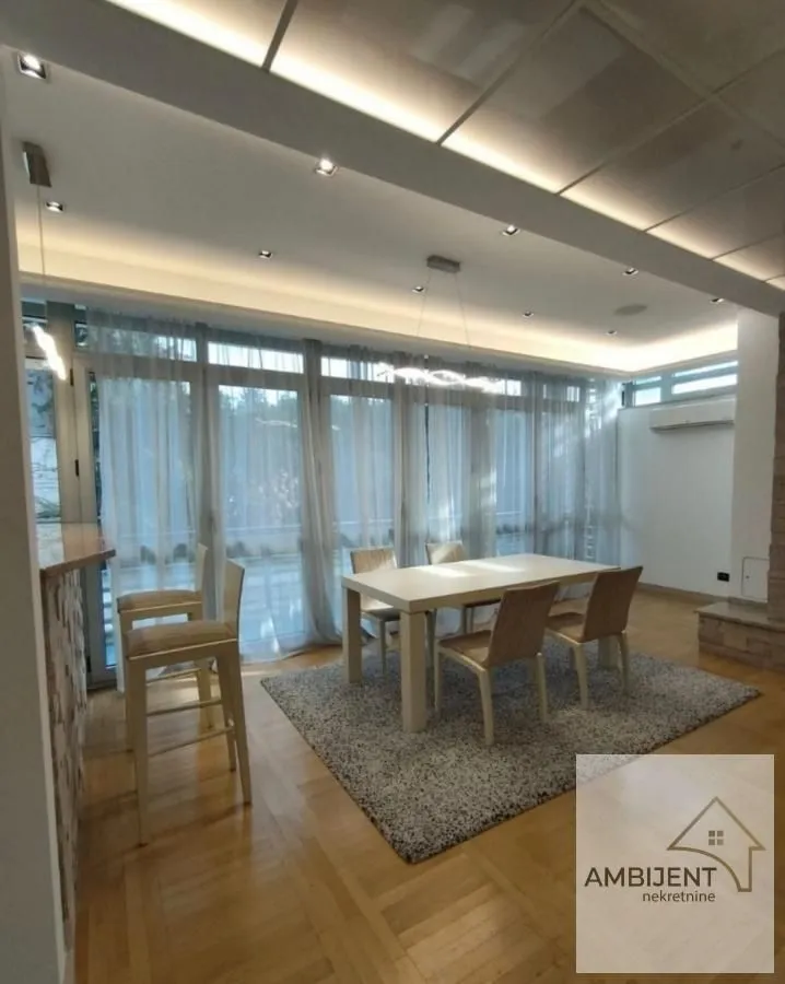 Spacious living room with a dining area and large glass surfaces.
