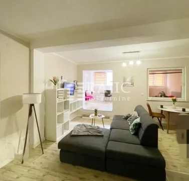 Living room with a sofa and dining area. - image 3