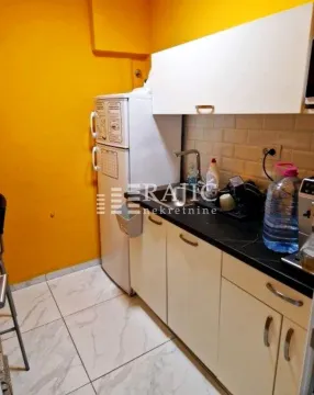 Small kitchen with white cabinets and a yellow wall. - image 11