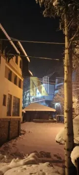 Pogled na zgradu i dvorište pod snegom noću. - image 16