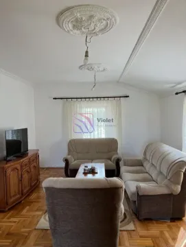 Dnevna soba sa garniturom za sjedenje, drvenom komodom i televizorom. - image 2