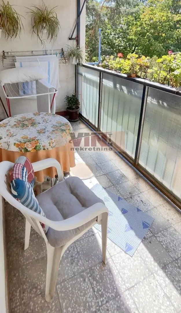Namešten balkon sa stolom, stolicama i sušilicom za veš.