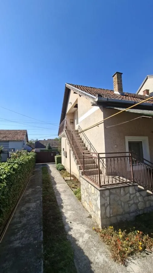 Spoljašnji izgled kuće sa dvorišnim prolazom i stepeništem.