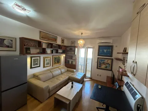 Living room with a sectional sofa, bookshelf units, and access to the balcony. - image 5