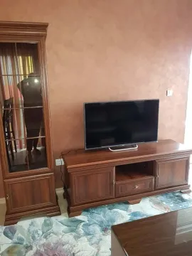 Living room with wooden furniture and a TV. - image 12