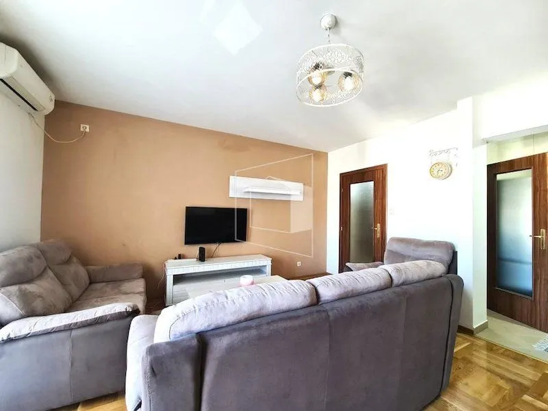 Furnished living room with a seating set and a television.