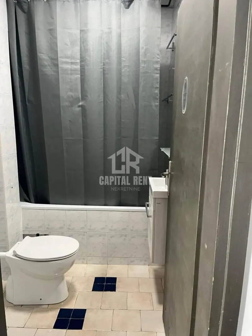 Smaller bathroom with a bathtub, toilet, and sink.