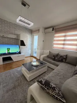 Dnevna soba sa garniturom, televizorom i dekorativnim zidom od cigle. - image 4