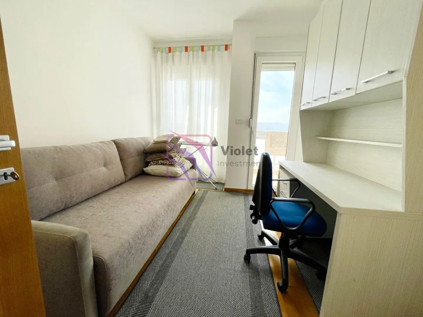 Small bedroom with a sofa bed and a desk.