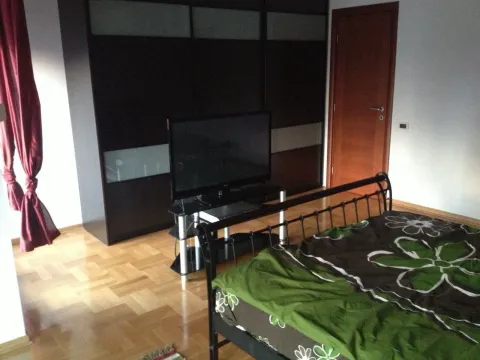 Simple bedroom with a large wardrobe and a TV. - image 7