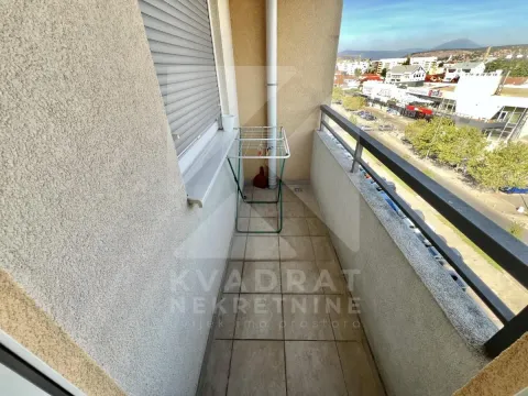 Narrow tiled balcony with metal railing and street view. - image 12