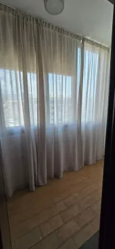 Zastakljena terasa sa svijetlim zavjesama i keramičkim pločicama na podu. - image 5