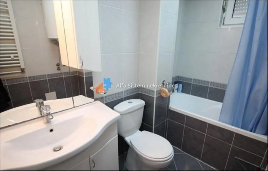 Bathroom equipped with a washbasin, toilet and a bathtub with a curtain.